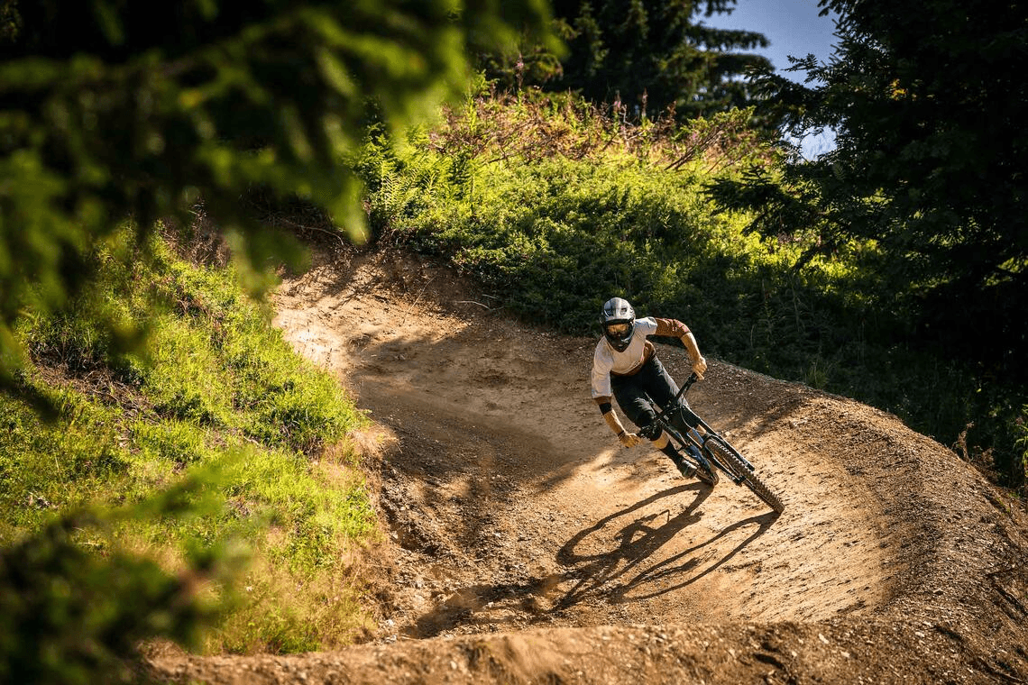 Rider carving a berm at Bikepark Les Gets